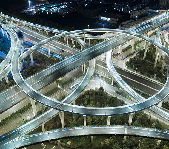 Aerial view of U.S. Highway 183 running through North Austin, Texas, showing busy traffic lanes, overpasses, and nearby commercial and residential developments under a clear blue sky.